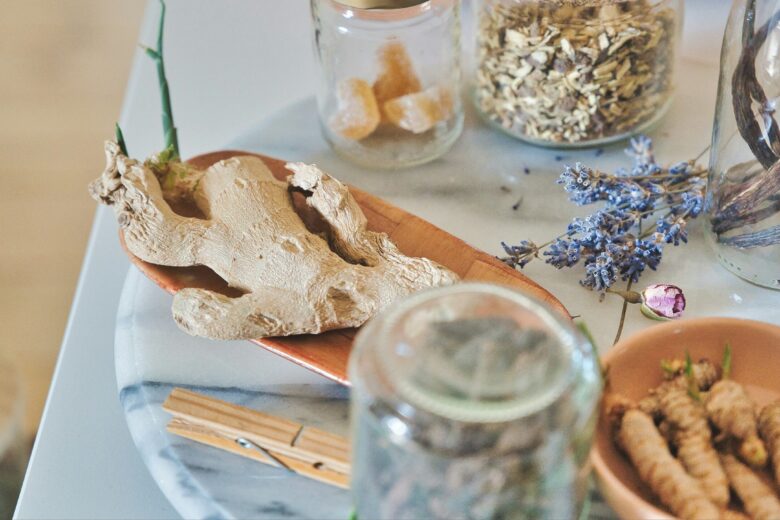 Meja dapur dengan berbagai rempah dan herbal, termasuk jahe, lavender, dan potongan gula