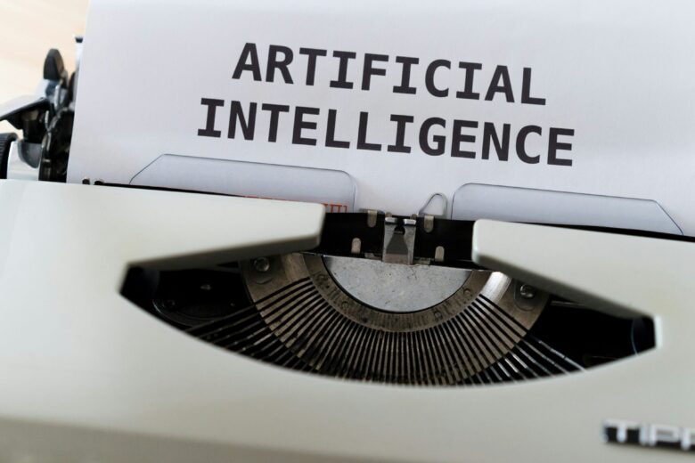 Mesin ketik kuno dengan kata-kata "ARTIFICIAL INTELLIGENCE" diketik pada selembar kertas.