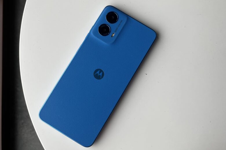 Gambar ponsel Motorola Moto G45 5G berwarna biru diletakkan di atas meja putih