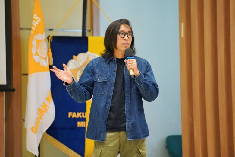 dr. Tirta sedang memberikan presentasi di depan audiens di suatu acara seminar.