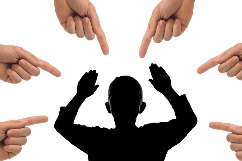 Seorang anak laki-laki dengan tangan terangkat dikelilingi oleh tangan yang menunjuk, menggambarkan tekanan sosial dan stigma