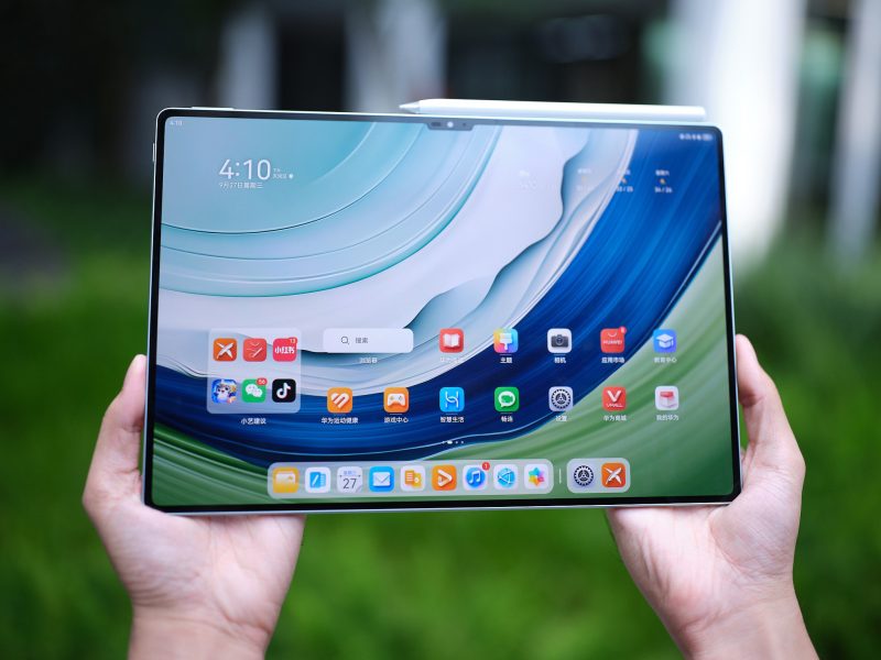 Tablet Huawei MatePad Pro 13,2 dengan antarmuka pengguna menarik dipegang di luar ruangan