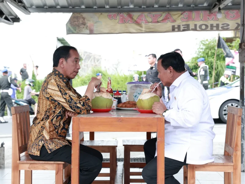 Joko Widodo dan Prabowo Subianto menikmati makanan bersama di sebuah warung sederhana.