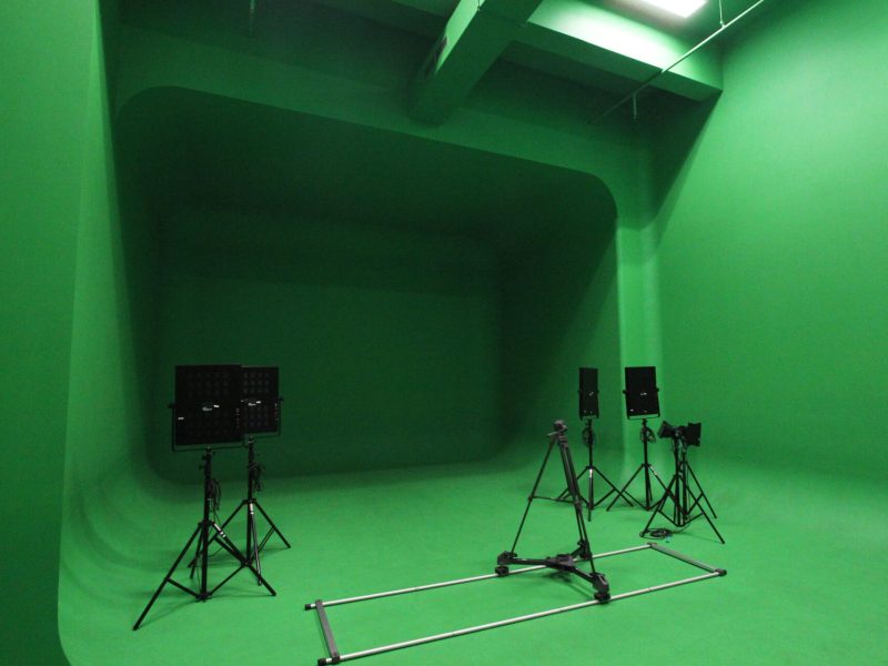 Studio green screen untuk pembuatan video dengan peralatan pencahayaan.