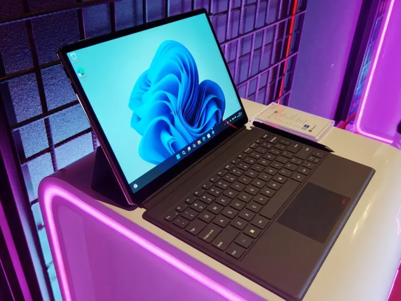 Advan Evo X 16 dengan layar Windows 11 dan keyboard terpasang di atas meja dengan pencahayaan neon.