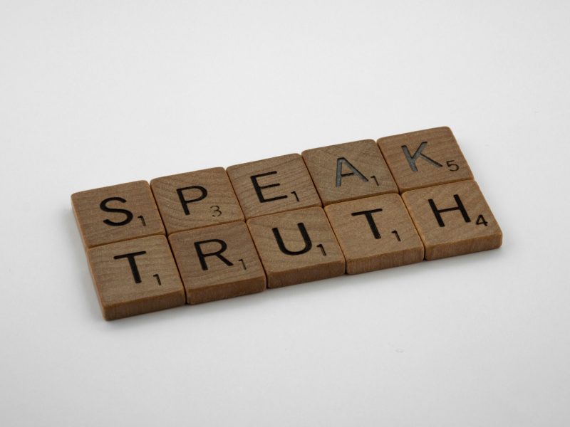 Kata-kata "Speak Truth" dieja dalam ubin huruf.