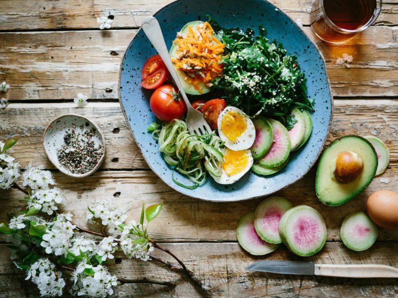 Piring berisi salad sayuran segar dengan telur rebus, irisan timun, dan alpukat.