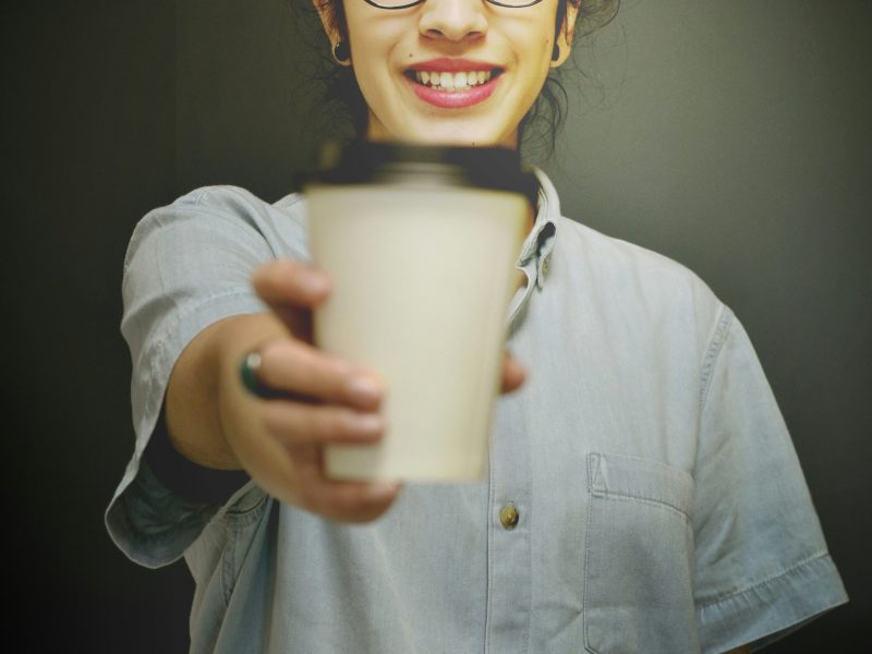 Wanita Menawarkan Secangkir Kopi Wanita tersenyum memegang secangkir kopi