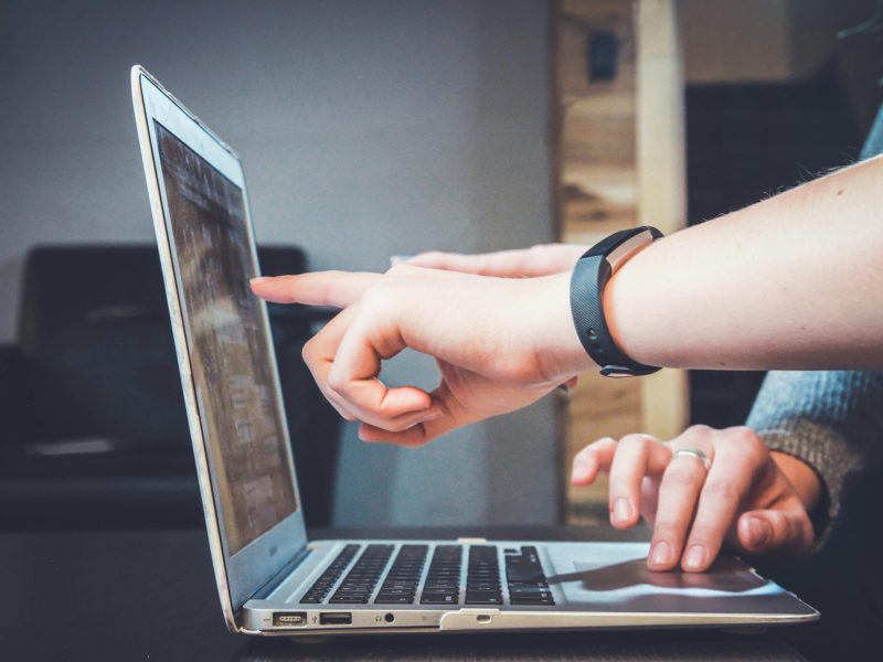 Kolaborasi Digital: Menggunakan Laptop untuk Mencapai Tujuan Bersama Tangan menggunakan laptop dengan fokus pada layar.