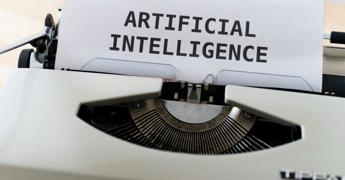 Kecerdasan Buatan di Mesin Tik Mesin ketik kuno dengan kata-kata "ARTIFICIAL INTELLIGENCE" diketik pada selembar kertas.