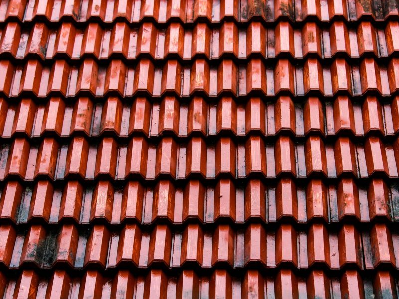 Atap Genteng Merah Foto close-up atap genteng merah. Genteng-genteng tersebut disusun dalam pola baris-baris yang saling tumpang tindih, sehingga menciptakan permukaan bertekstur.