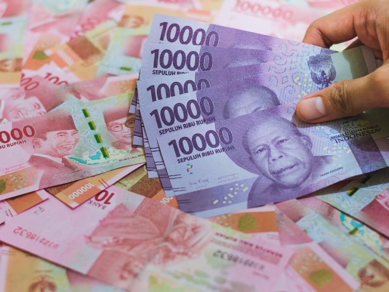 Tumpukan uang rupiah Indonesia, termasuk pecahan sepuluh ribu dan seratus ribu.